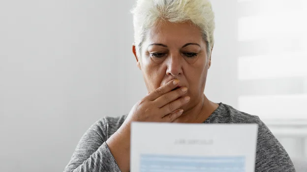 Ultrasonido de mama precio: mujer viendo asombrada un hoja